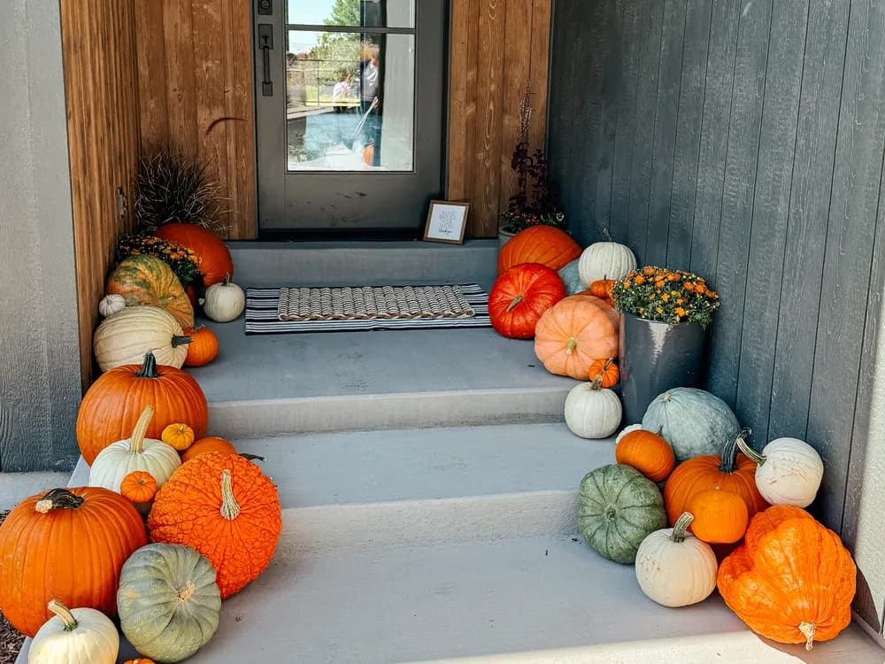 Complete autumn porch transformation with pumpkins cascading down gray board-and-batten steps